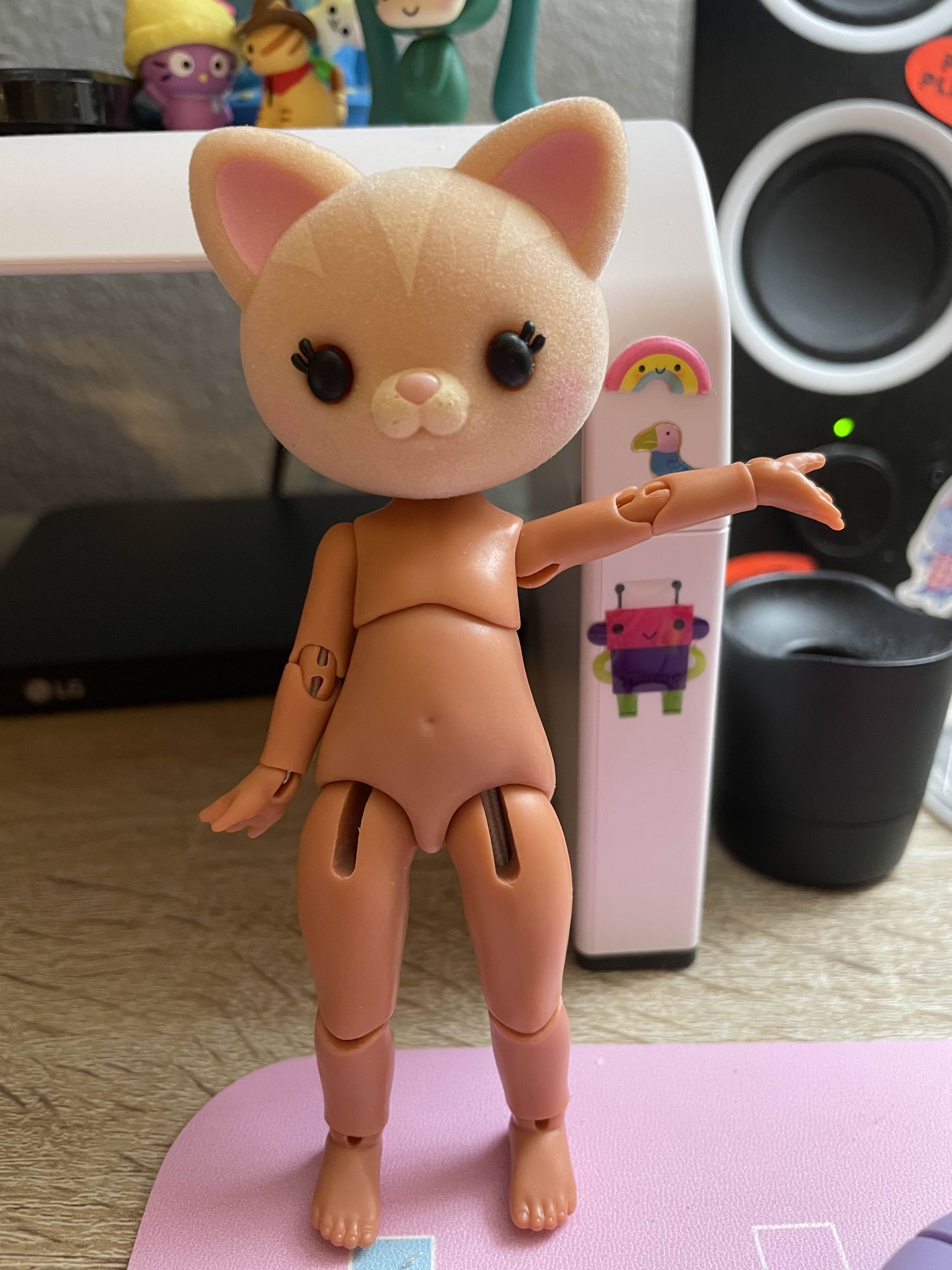 A cat head on a small string-jointed doll body.
