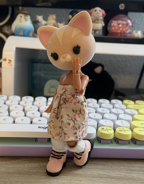 The same hybrid doll wearing a floral skirt, pink shoes, and white socks.